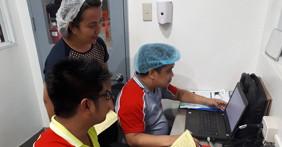 Image of Grace working with other Group staff at the Philippines factory
