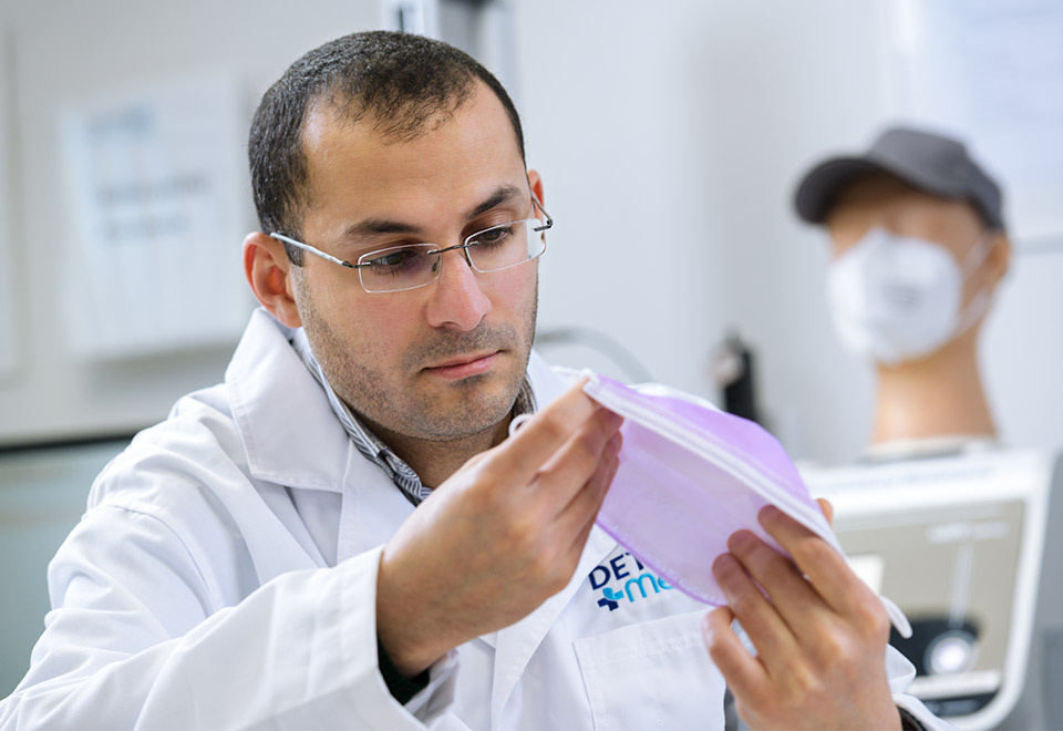 Ahmed Bilasy studies a face mask in the lab